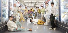 a group of young men standing and sitting in front of refrigerators filled with food