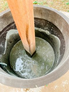 a bucket filled with water next to a wooden handle