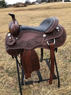 a brown and black saddle sitting on top of a wooden stand