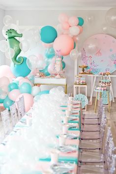 a long table with balloons and decorations on it