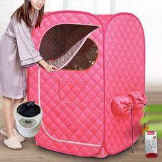 a woman standing next to a pink portable shower