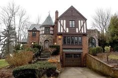 a large brick house with two story windows and an attached walkway leading up to the front door