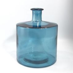 a blue glass vase sitting on top of a white table