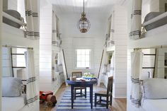 bunk beds are lined up against the wall in this small room with blue and white rugs