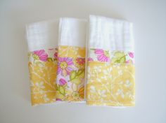 two towels are folded on top of each other, one is yellow and the other is white