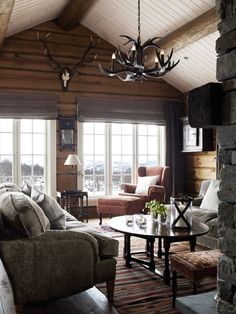 a living room filled with furniture and a deer head mounted to the wall above it