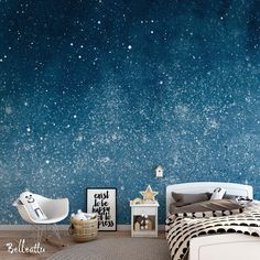 a bedroom with stars painted on the wall and a bed in the foreground, next to a night sky mural