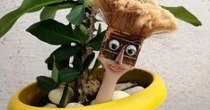 a yellow planter with a fake hair doll sticking out of it's face