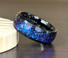 Men's Laser Engrave Black IP Blue Synthetic Opal & Abalone Fragments Tungsten Wedding Ring * Width: 8mm * Blue Synthetic Opal & Abalone Fragments * Hypoallergenic * Free Laser Engraving * Ring box included Tungsten Carbide Rings - General Information  Tungsten rings are very resistant to scratching. They are durable and won't bend out of shape like silver and gold rings. But they do have brittle properties and can break/crack if they encounter significant impact with hard objects. The original c Silver And Gold Rings, Engraved Ring Box, Engraving Ring, Tungsten Rings, Tungsten Wedding Rings, Jewelry Cleaning Solution, Clean Towels, Tungsten Carbide Rings, Synthetic Opal