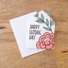 two greeting cards with the words happy closing day printed on them, sitting on a wooden surface