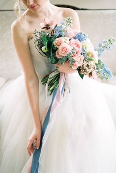 a woman in a wedding dress holding a bouquet