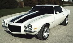 a white and black striped muscle car parked on the street