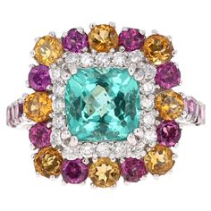 Gorgeous Apatite, Purple Garnet, Citrine and Diamond Ring. This ring has a 2.07 Carat Cushion Cut Apatite in the center of the ring and is surrounded by 20 Round Cut Diamonds that weigh 0.33 carats (Clarity: SI, Color: F). It is also embellished with 18 Purple Garnets that weigh 1.70 Carats and 8 Citrines that weigh 0.82 Carats. The total carat weight of the ring is 4.92 Carats. Apatites are found in various places around the world including Myanmar, Kenya, India, Brazil, Sri Lanka, Norway, Mexi Purple Garnet, Sea Blue Color, Sapphire Cocktail Ring, Apatite Stone, Gold Cocktail Ring, Gold Cocktail, Diamond Cocktail Rings, Fine Jewels, Floral Jewellery