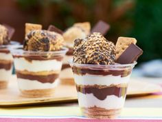 desserts in small cups with chocolate and marshmallow toppings on the side