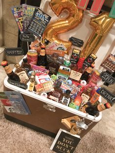 a trunk filled with lots of different types of liquors and condiments next to a number two balloon