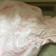 a wedding dress is laying on the floor