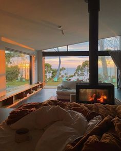 a living room filled with furniture and a fire place next to a large glass window