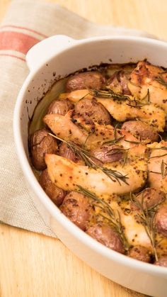 a casserole dish with chicken, potatoes and herbs