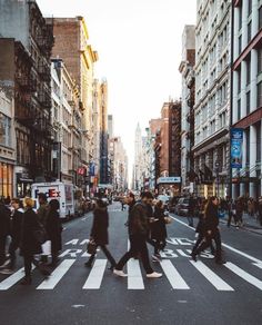 many people are crossing the street at an intersection