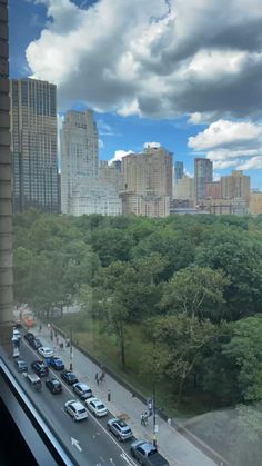 cars are parked on the street in front of tall buildings and skyscrapers as seen from a window