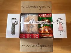 an open box with some food in it on top of a wooden table next to greeting cards