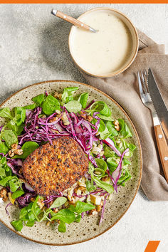 a plate with meat, lettuce and salad next to a cup of milk