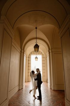 a bride and groom standing in an archway