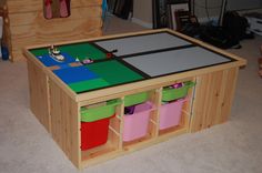 a child's play table with bins and toys in it on the floor