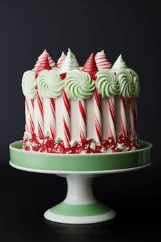 a green and white cake topped with lots of candy canes