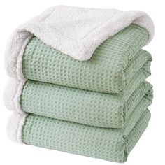 four towels stacked on top of each other in mint green and white colors, with one folded