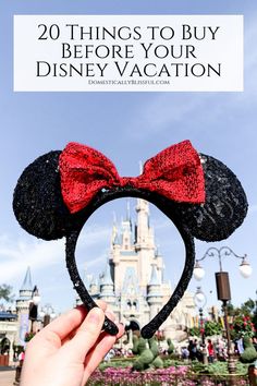 a hand holding up a minnie mouse ears headband with the words 20 things to buy before your disney vacation