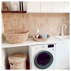 a washer and dryer sitting on top of a counter next to a basket