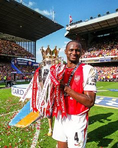 a man holding a trophy on top of a field