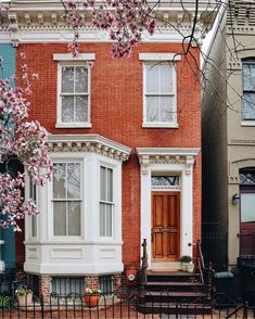 a red brick house with white trim on the front door and steps leading up to it