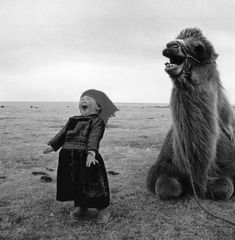 a small child standing next to a large animal