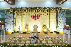 an elaborate stage set up for a wedding ceremony with flowers and decorations on the wall