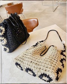 two crocheted bags sitting on top of a table