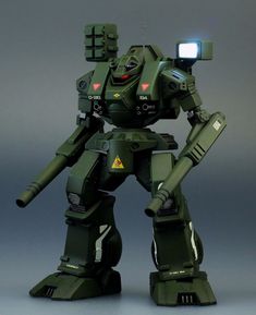 a green robot that is standing up with its arms out and eyes closed, holding a light