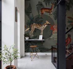 an animal themed wallpaper with deer and plants in the background, along with two stools