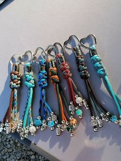 several different colored bracelets with charms attached to them on top of a white surface