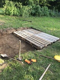 a wooden pallet laying on top of a lush green field