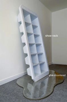 a large white book shelf sitting on top of a gray floor next to a wall