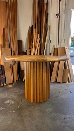 a wooden table surrounded by stacks of wood planks