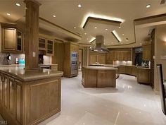 a large kitchen with wooden cabinets and an island in front of the stove top oven