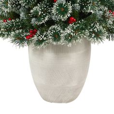 a white vase filled with snow and red berries