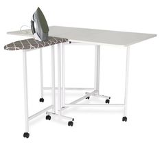 an ironing board sitting on top of a white table next to a ironing board