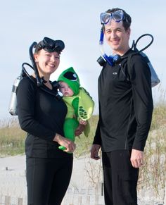 a man and woman in scuba gear holding a baby