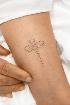 a woman's arm with a small tattoo on it