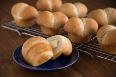 several rolls on a cooling rack next to a blue plate