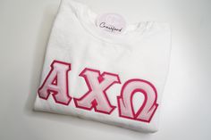 a white shirt with the word axo embroidered on it